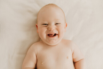 child lying on bed, smiling baby boy