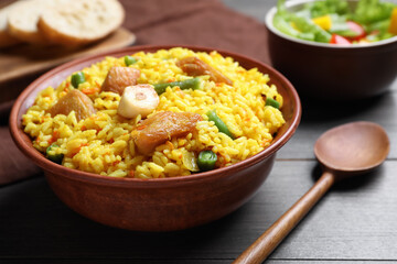 Delicious pilaf with chicken meat on wooden table