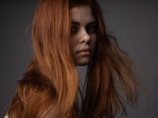 Naklejka premium Red hair beautiful woman gray background portrait close-up