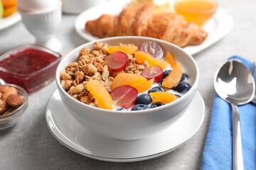 Delicious granola with fruits served on white table