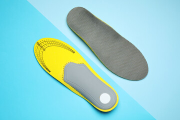 Orthopedic insoles on light blue background, flat lay