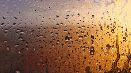 Natural background of condensation, drops of flowing water on the window pane