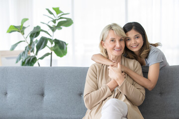 Happy mix skin family living together, adopted caucasian mother and Asian daughter cuddle each...