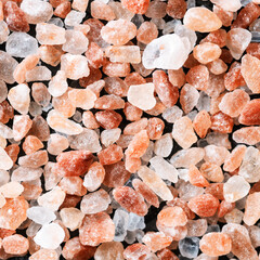 Himalayan pink rock salt on black background. Top view.