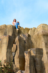 Tourists climb up the basalt pillars, tourist places of Ukraine, natural stone of the basalt rock.