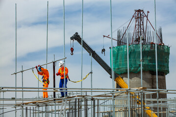 Oil refinery plant modernization. Industrial climbers on assembling scaffolding. Construction of...