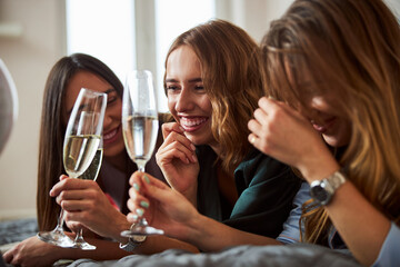 Joyous woman drinking champagne with her friends
