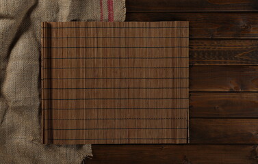 Old vintage jute sack and table mat on on wooden planks, table background and texture, top view