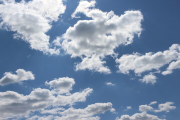 blue day sky with white fluffy clouds horizontal background