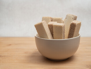 A bowl of a neapolitan waffles on a wooden table. Close-up.