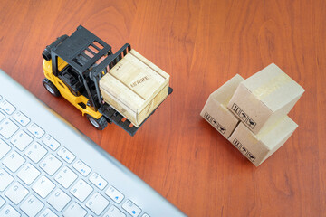 Forklift truck handing cargo shipping container box with keyboard and carton box use as online...
