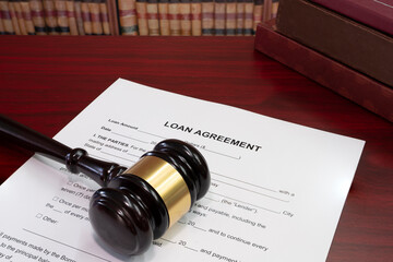 Law, loan in business concept. Gavel with business loan agreement as legal document concept. Gavel with loan agreement contract preparation for filling.