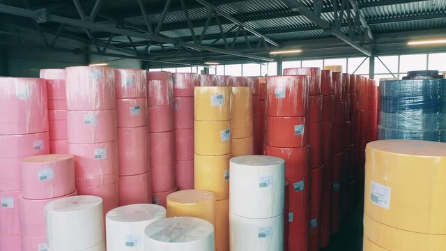 Many colorful paper rolls stored at a big warehouse