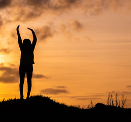 Woman enjoying sunset, silhouette at Sao Miguel island at the Azores.