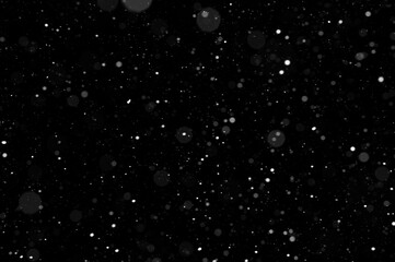 Bokeh of white snow on a black background. Snowfall - design element.