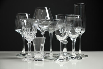 Set of bar glassware on white table against black background