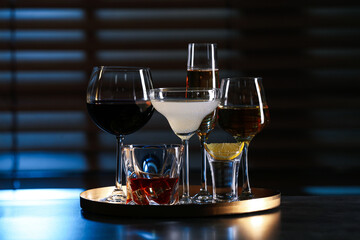 Tray with different alcohol drinks on table indoors