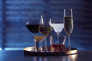 Tray with different alcohol drinks on table indoors