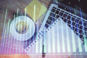 Double exposure of forex chart drawing over table background with computer. Concept of financial research and analysis. Top view.
