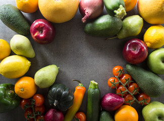 Colorful frame or border made of fresh seasonal vegetables.  Dark grey textured background with copy space.  healthy eating concept. 