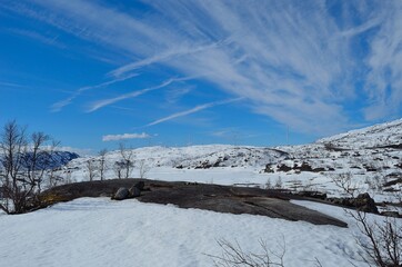 windmill farm on snowy mountain in northern Norway in bright sunshine and blue sky backdrop