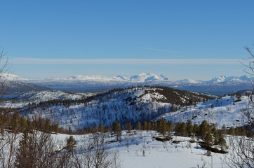 Deep snow covered mountain range on a sunny day in Northern Norway.