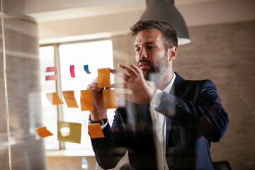 Businessman in conference room. Young businessman in suit making a business plan © JustLife