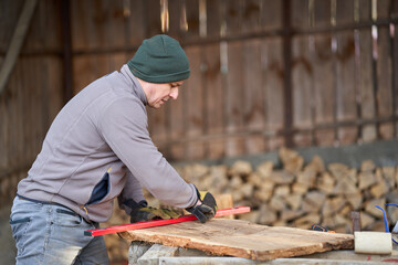 Carpenter measuring and drawing walnut wood
