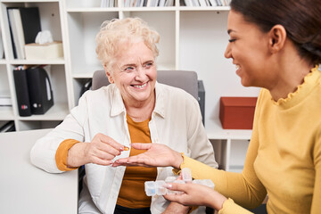 Female talking to elderly patient about vitamins