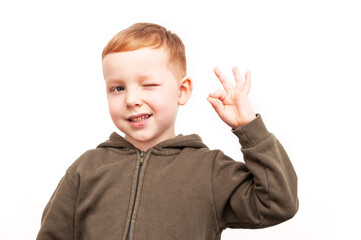 Portrait of a cute little boy kid showing okay gesture isolated on white