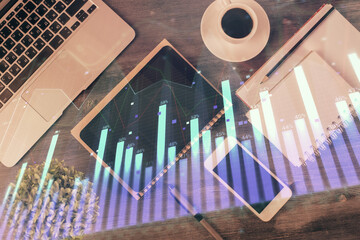 Double exposure of forex chart hologram over desktop with phone. Top view. Mobile trade platform concept.