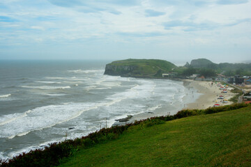 Fototapeta na wymiar Beautiful shot of the shore washed by ocean waves on a gloomy day in Brazil