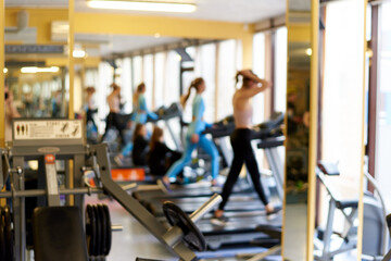Fototapeta premium Defocused background of treadmills with people in the gym.