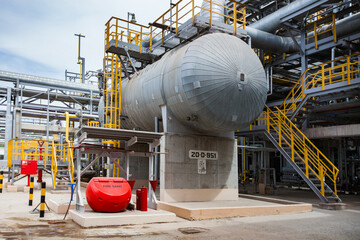 Petrochemical industry. Modern oil refinery plant. Grey heat exchanger and pipelines. Red plastic...