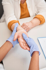 Fototapeta na wymiar Doctor examining her senior patient's arm in a clinic