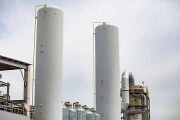 White tanks on grey sky background. Oil refinery plant (refining complex). Close-up.