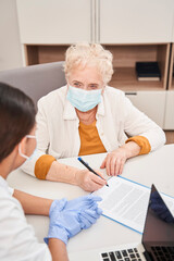 Obraz premium Doctor with patient writing prescription on special form