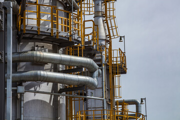 Close-up of distillation tower (column) on blue sky background. Oil refinery plant. Refining...