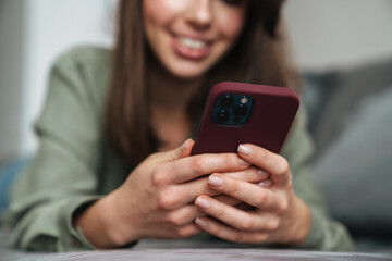 Close up of a smiling attractive woman holding mobile phone