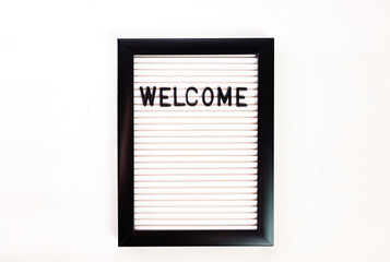 Welcome, word written with white plastic letters on felt message board, large copy space isolated on white background