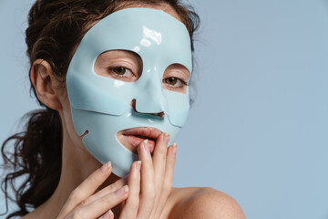 Beautiful half-naked nice girl posing with facial mask