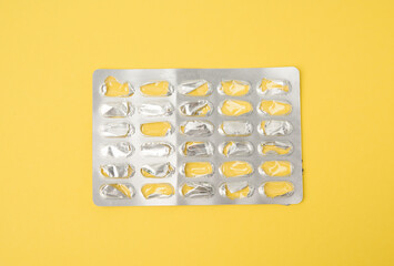blank blister pack of capsule pills on a yellow background - obrazy, fototapety, plakaty