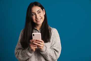 Fototapeta premium Happy beautiful asian girl smiling and using smartphone