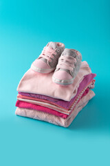 Baby rompers and baby shoes on blue background