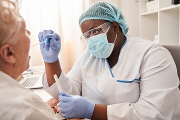 Fototapeta premium Nurse taking a sample from potentially infected woman