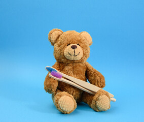  brown teddy bear with a wooden toothbrush on a blue background
