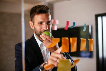 Businessman in conference room. Young businessman in suit making a business plan