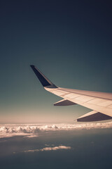 Fototapeta premium Top view from inside window airplane of a blue sky and wing