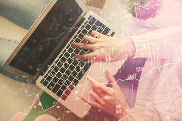 Double exposure of woman hands working on computer and forex chart hologram drawing. Top View. Financial analysis concept.