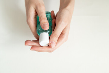 Female hands with a alcohol antibacterial sanitizer bottle for disinfection